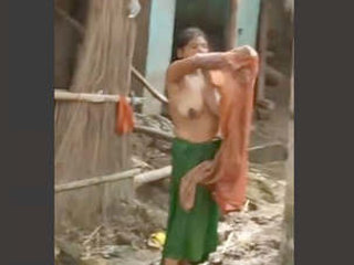 Indian wife bathes outdoors