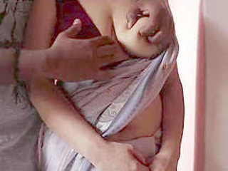 Indian wife with large breasts gets hugged by her husband while wearing a saree